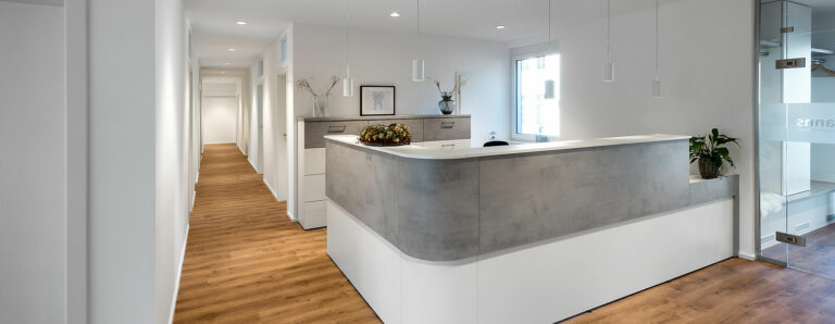 Ein Empfangsbereich eines Büros oder einer Praxis mit moderner Innenbeleuchtung.