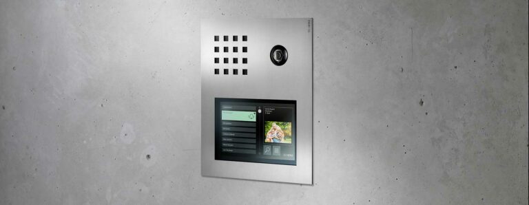 Eine moderne Sprechanlage mit Videoübertragung ist in eine Sichtbetonwand integriert.